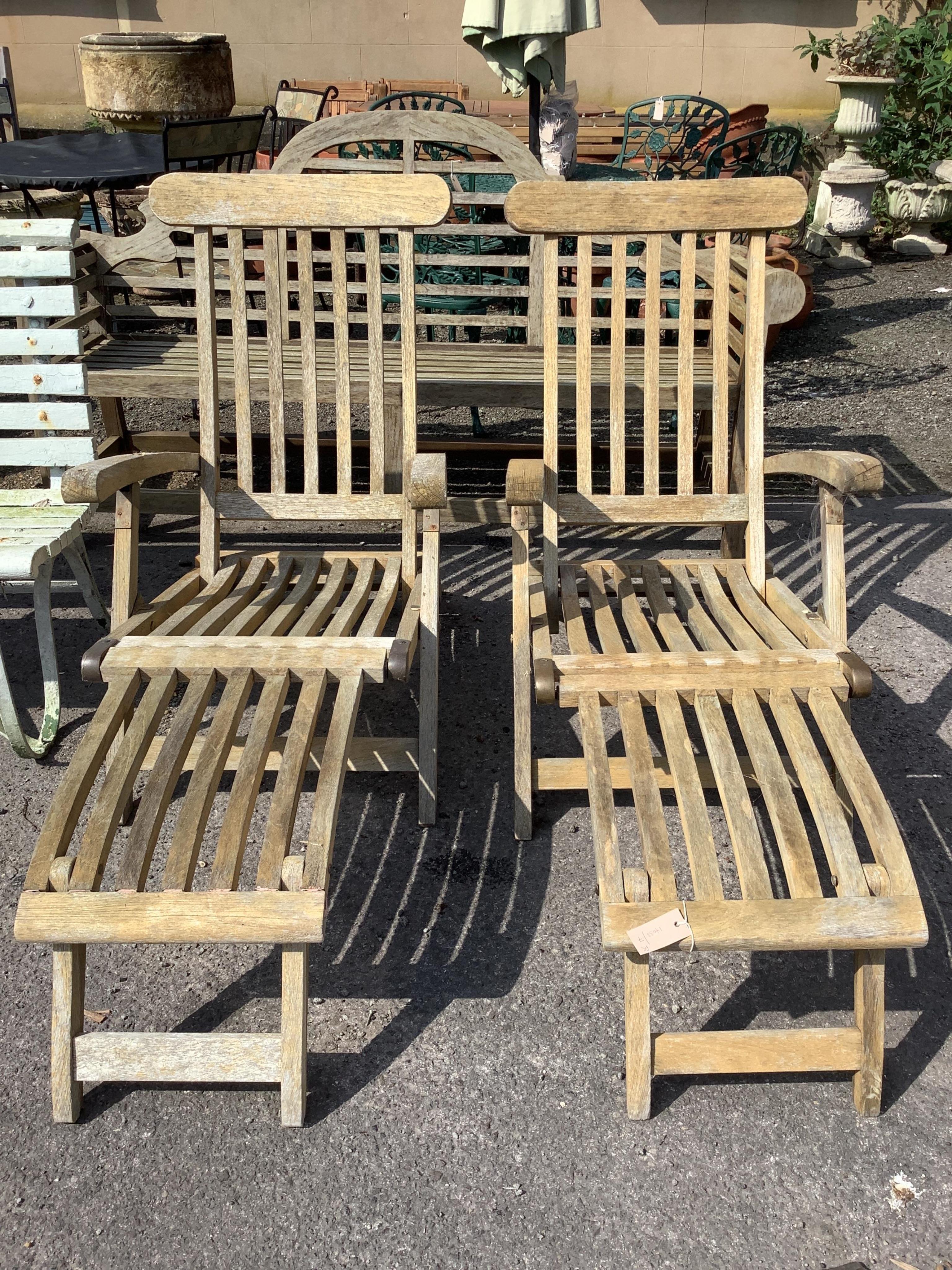 A pair of brass mounted weathered teak garden steamer chairs, width 61cm, height 96cm